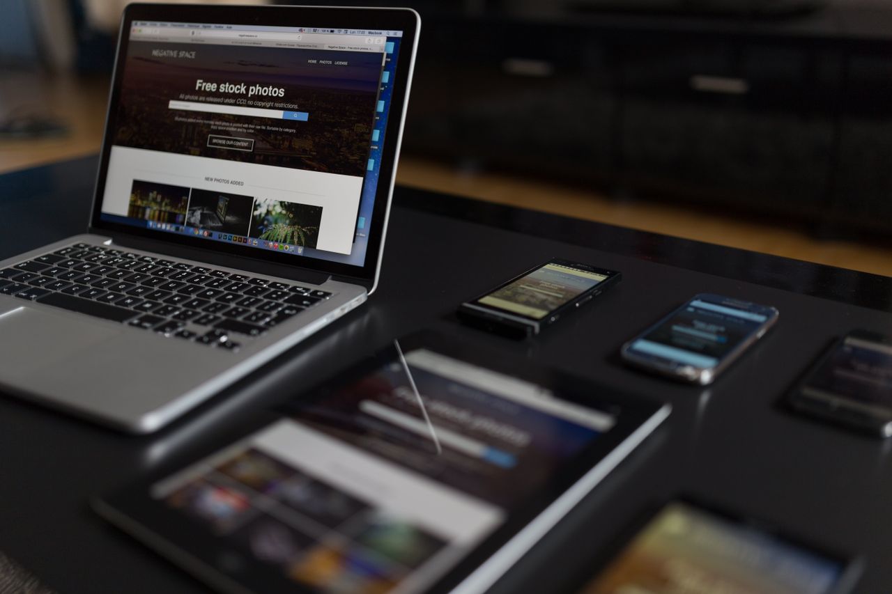 A modern workspace featuring a laptop, tablet, and smartphones, perfect for tech and freelance use.